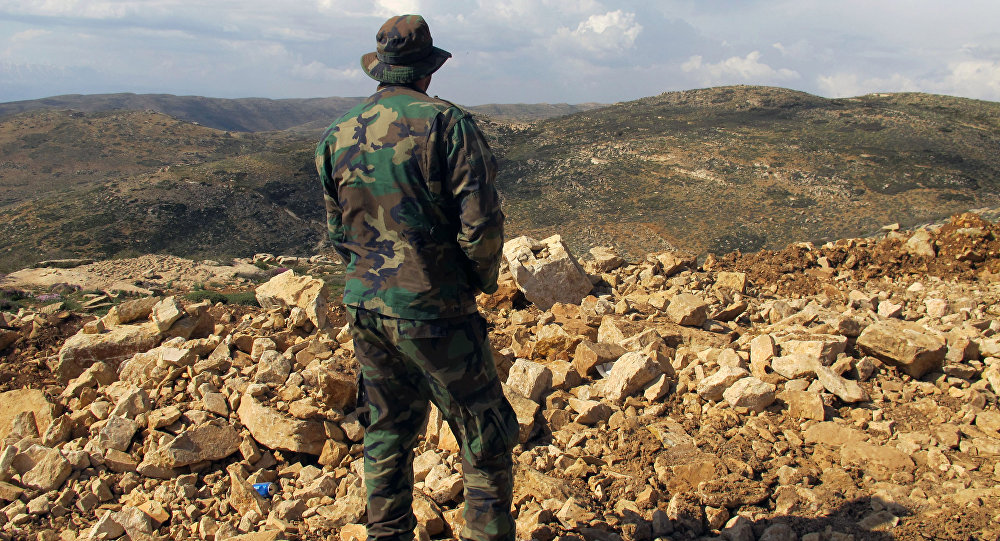 Combatente do Hezbollah em Brital, no Líbano, olha na direção da Síria