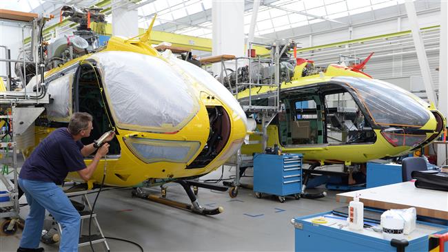 Este arquivo de foto AFP taken on 09 de outubro de 2014 mostra os empregados que trabalham na linha de produção de helicópteros da Airbus na fábrica de Donauwoerth, sul da Alemanha.