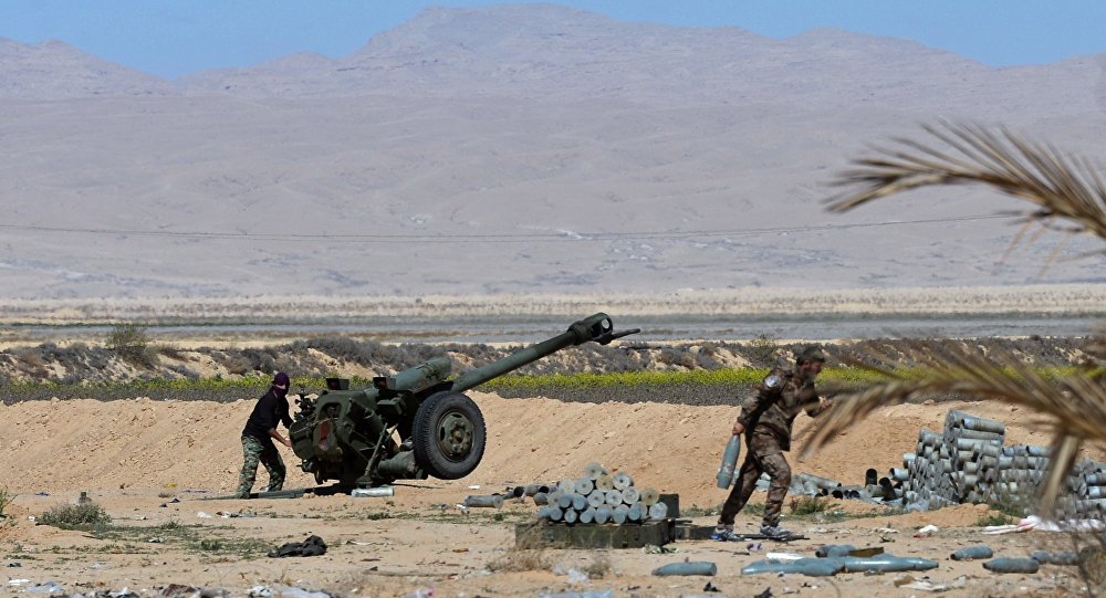 Militares sírios lançam fogo da peça de artilharia D-30 contra as posições de militantes nos arredores de Palmira, Síria, 14 de março de 2016