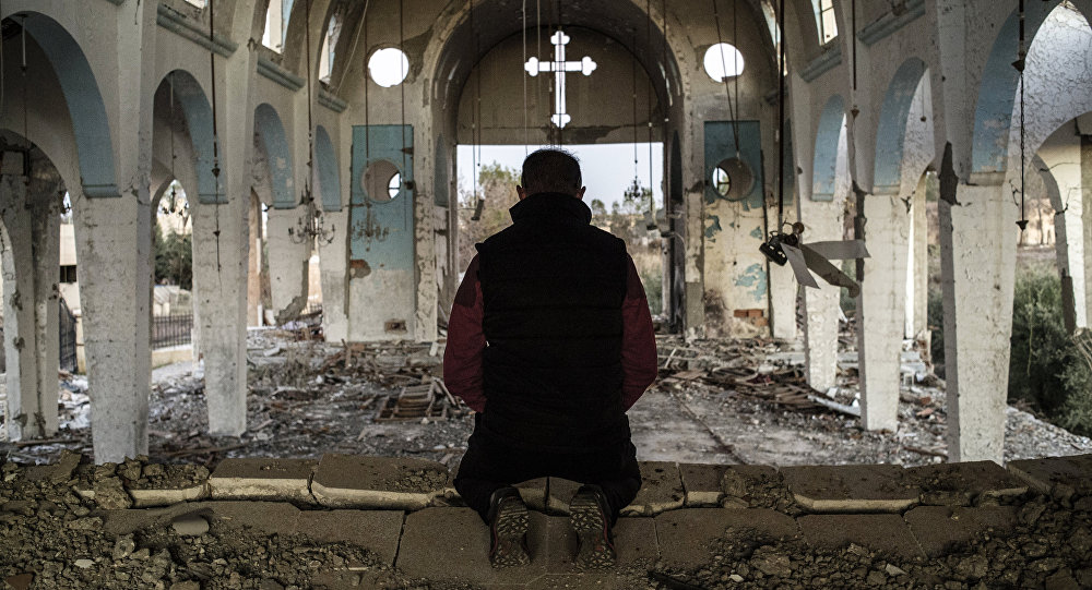 Cristão de vilarejo no nordeste da Síria reza em igreja destruída pelo Estado Islâmico