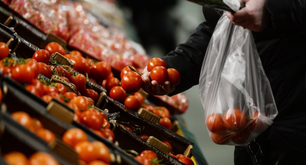 Comprador no supermercado russo escolha tomates