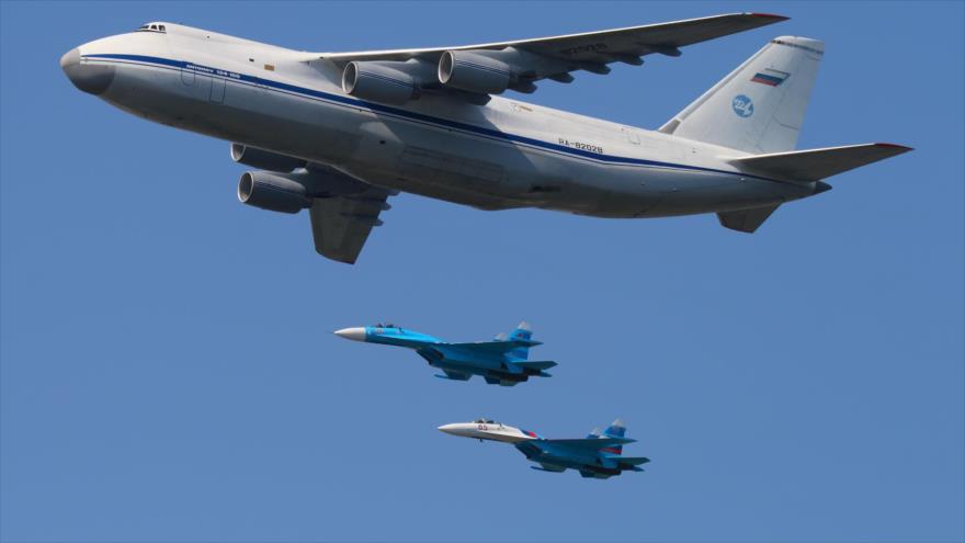 Dos cazas rusos tipo Su-27 escoltan un avión de pasajeros Antonov An-124.