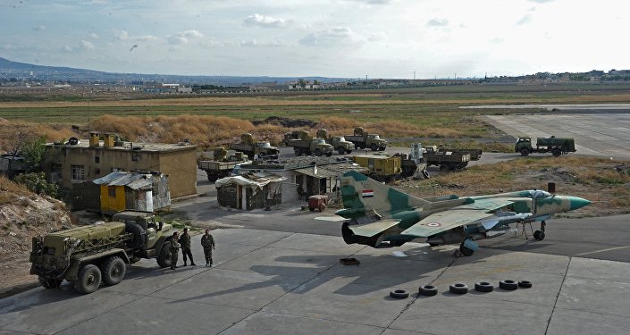 A base aérea de Hama. Carros russos e o caça MiG-23 russo das Forças Aéreas da Síria