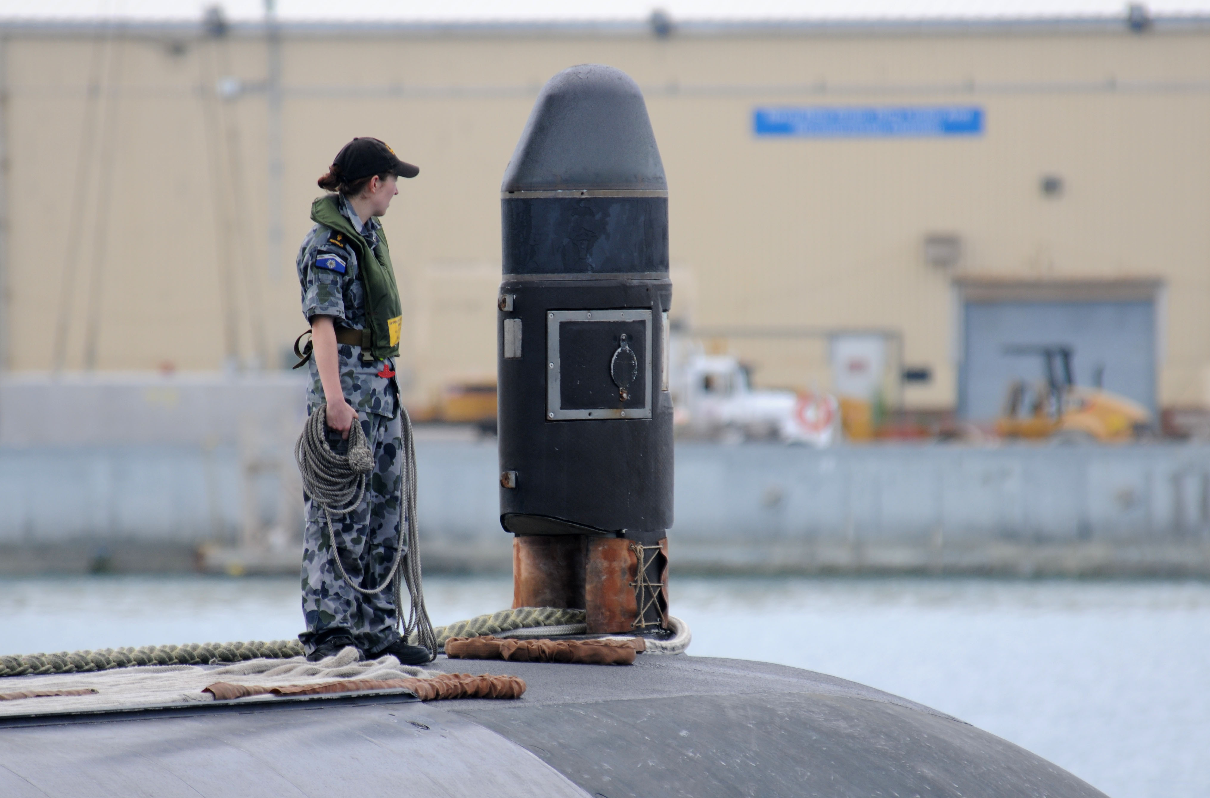 An Australian navy submariner aboard HMAS Waller (SSG 75) prepares to throw a receiving line as the submarine pulls into Apra Harbor, Guam, for a port call. This is the first visit to Guam by an Australian navy submarine since 2008. (U.S. Navy photo by Mass Communication Specialist 1st Class Jeffrey Jay Price/Released)