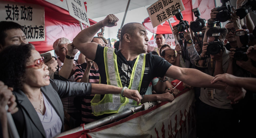 A pro-Beijing protester tries to punch a pro-democracy demonstrator after a heated argument outside the government building in Hong Kong on April 22, 2015.