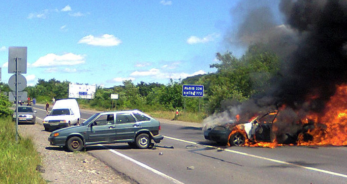 A police car is seen on fire at the site of unrest in Mukachevo, Western Ukraine, Saturday, July 11, 2015.