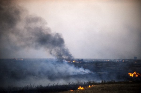 O campo queima perto do local da queda dos destroços de um avião de caça ucraniano perto da aldeia de Zhdanivka, a cerca de 40 quilômetros a nordeste do reduto rebelde de Donetsk, leste da Ucrânia.